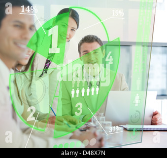 Business people using green pie chart interface Stock Photo