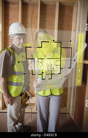 Architect and foreman checking the plans on interface Stock Photo
