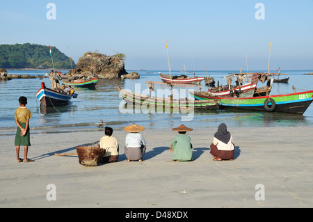 Family waiting for returning fishing boats, Ngapali Beach, Thandwe, Rakhine State, Myanmar Stock Photo