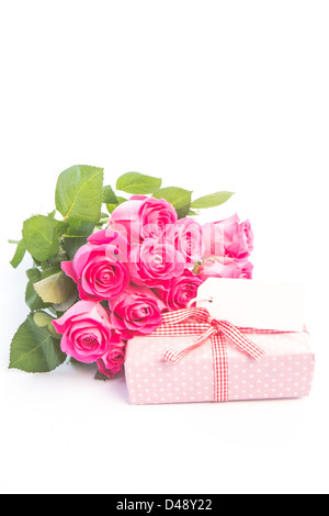 Bouquet of roses next to a gift with a blank card Stock Photo