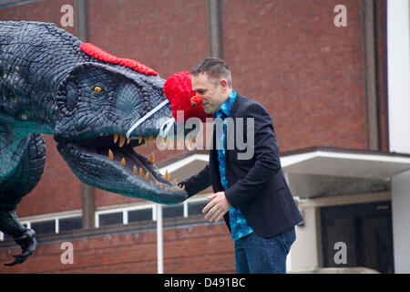 Bournemouth, UK. 8th March 2013. COMEDY Darren the dinosaur is released onto the streets of Bournemouth in aid of Comic Relief. Darren the dinosaur is three metres tall by eight metres long and was used in Walking with Dinosaurs, He was set free by celebrity Chris Jarvis from outside the BIC. The event was organised by Sainsbury's to encourage people to call into any store to get their red noses to protect themselves should they see the prehistoric creature while out and about. Credit:  Carolyn Jenkins / Alamy Live News Stock Photo