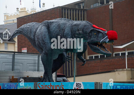 Bournemouth, UK. 8th March 2013. COMEDY Darren the dinosaur is released onto the streets of Bournemouth in aid of Comic Relief. Darren the dinosaur is three metres tall by eight metres long and was used in Walking with Dinosaurs, He was set free by celebrity Chris Jarvis from outside the BIC. The event was organised by Sainsbury's to encourage people to call into any store to get their red noses to protect themselves should they see the prehistoric creature while out and about. Credit:  Carolyn Jenkins / Alamy Live News Stock Photo