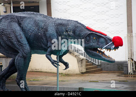 Bournemouth, UK. 8th March 2013. COMEDY Darren the dinosaur is released onto the streets of Bournemouth in aid of Comic Relief. Darren the dinosaur is three metres tall by eight metres long and was used in Walking with Dinosaurs, He was set free by celebrity Chris Jarvis from outside the BIC. The event was organised by Sainsbury's to encourage people to call into any store to get their red noses to protect themselves should they see the prehistoric creature while out and about. Credit:  Carolyn Jenkins / Alamy Live News Stock Photo