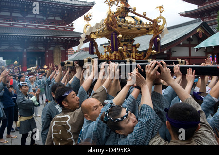 Gold decorated sacred mikoshi portable shrine carried around Sensoji Temple Hozomon Gate during Sanja Matsuri Festival. Stock Photo