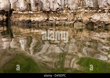 Rocks at the lakeshore of Lago Bayano (lake) with abstract reflections in the water, Panama province, Republic of Panama. Stock Photo