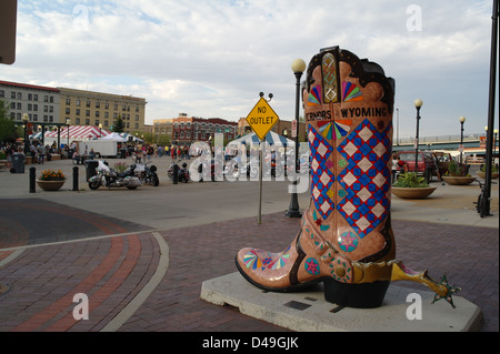 Evening view giant cowboy boot, 'Governors of Wyoming', towards people, motorbikes, tents, Depot Plaza, Cheyenne, Wyoming, USA Stock Photo