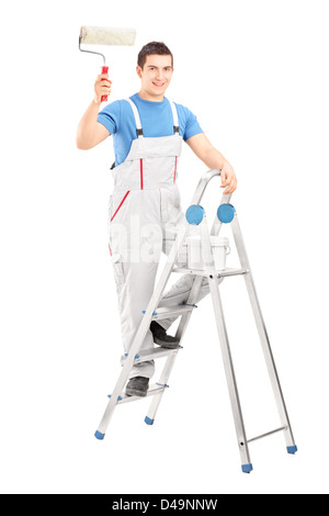 Full length portrait of a male painter holding a roller and standing on a ladder isolated on white background Stock Photo