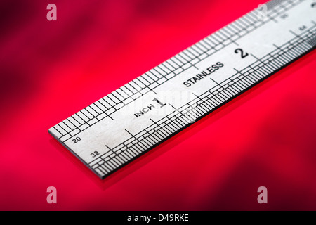 This is an image of a ruler, cut out over a red background. Stock Photo