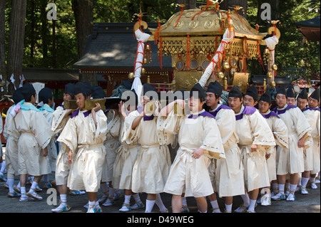 Participants at Futarasan Shrine for annual spring Shunki Reitaisai festival in Nikko, Tochigi, Japan carry gold mikoshi shrine Stock Photo