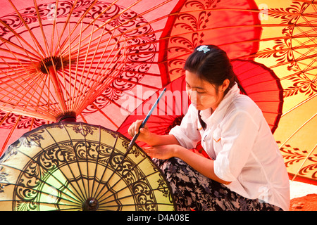 Young woman painting decorative designs at umbrella workshop in Old Bagan, Myanmar (Burma) Stock Photo