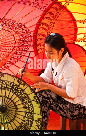 Young woman painting designs at umbrella workshop in Old Bagan, Myanmar (Burma) Stock Photo