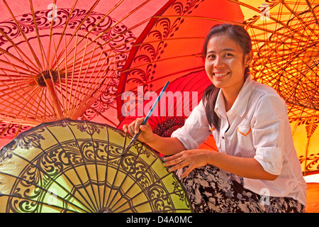 Young woman painting decorative designs at umbrella workshop in Old Bagan, Myanmar (Burma) Stock Photo