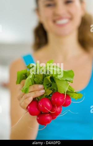 Closeup on bunch of radishes in hand of young woman Stock Photo