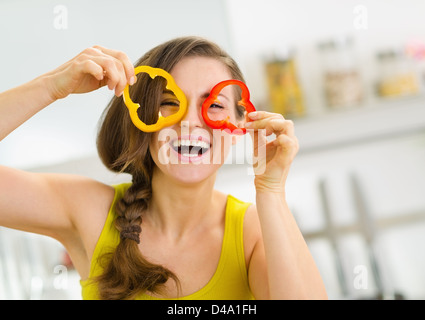 Funny young woman showing slices of bell pepper Stock Photo