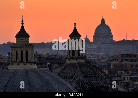 italy, rome, the domes of santa maria in montesanto, santa maria dei miracoli and st peter's basilica at sunset