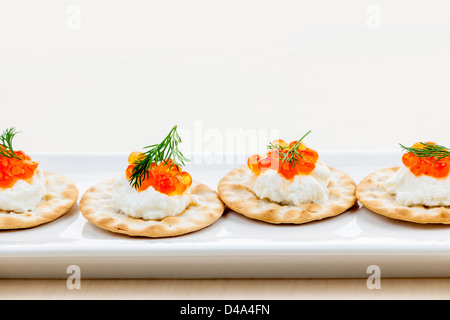 Caviar appetizer with goat cheese and crackers on white plate Stock Photo