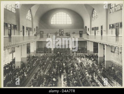 Immigrants seated on long benches, Main Hall, U.S. Immigrati... Stock Photo