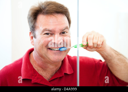 Happy, smiling man brushing his straight white teeth.  Stock Photo