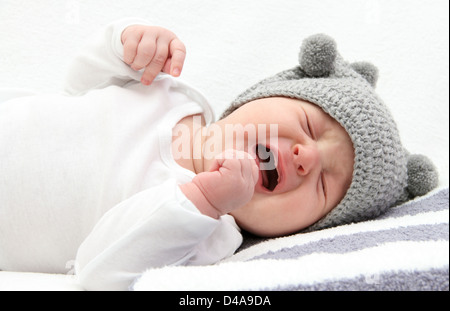 little baby crying on bed Stock Photo
