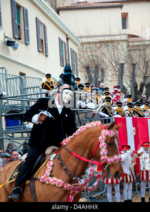 A 'masked horseman' pierces a star with his sword at 'Sa Sartiglia' during the 'race to the silver star' Stock Photo