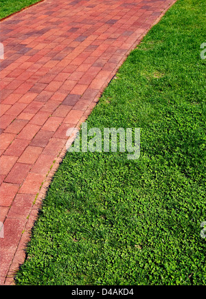 A brick pathway with a well manicured lawn. Stock Photo