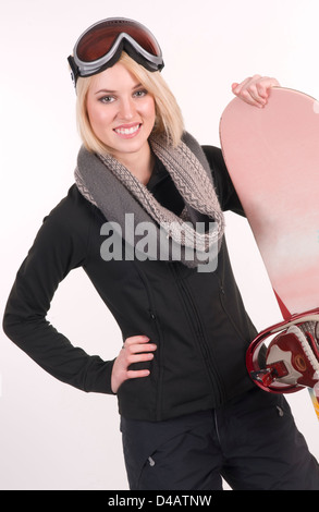 A Happy Sports Woman in Black Stands in Full Gear with her Snowboard Stock Photo