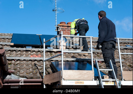 fitting photovoltaic cells to house roof Stock Photo