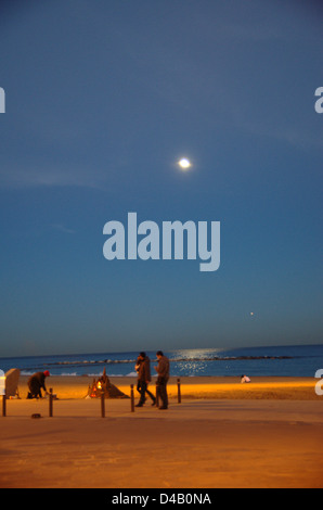 Ambient on the Barcelona beach at night. One person makes sand castles. Stock Photo