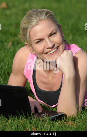 Woman beside her notebook computer on the grass Stock Photo