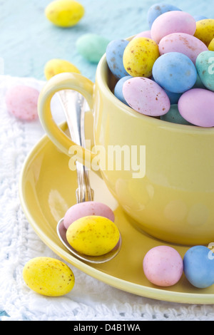 Easter eggs in a yellow cup on wooden vintage background Stock Photo