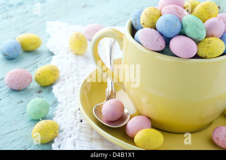 Easter eggs in a yellow cup on wooden vintage background Stock Photo