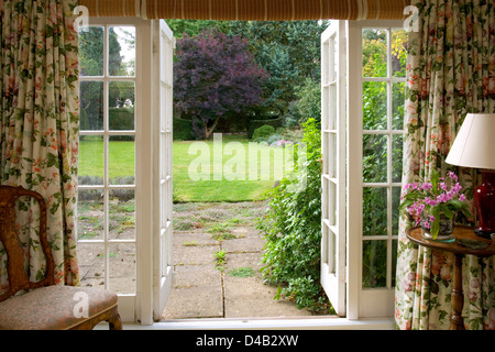 Traditional french windows opening onto a mature lawned garden. Stock Photo