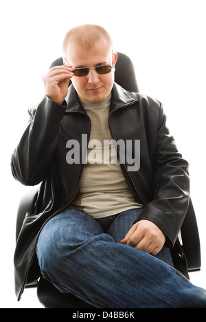 Young successful man in sunglasses sitting on chair Stock Photo