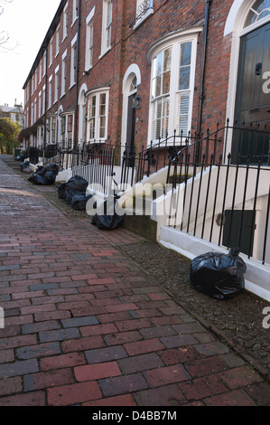 Paved street alley way with no vehicle access to well maintained Victorian houses making refuse collection difficult as on hill Stock Photo