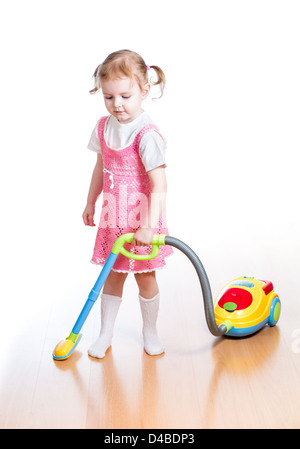 kid girl playing and cleaning room with toy vacuum cleaner Stock Photo