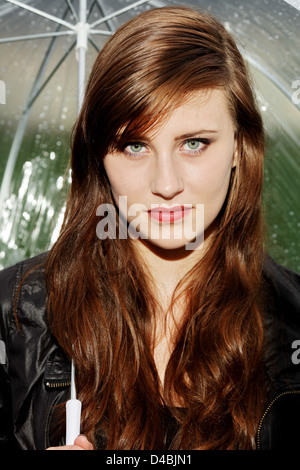 Young woman with umbrella in the rain Stock Photo