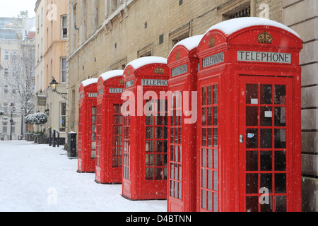 Red phone boxes in Broad Street, off Bow Street, in Covent Garden, London, in the snow, in winter, in England, UK Stock Photo