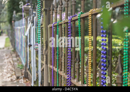 mardi gras beads hanging on fence Stock Photo