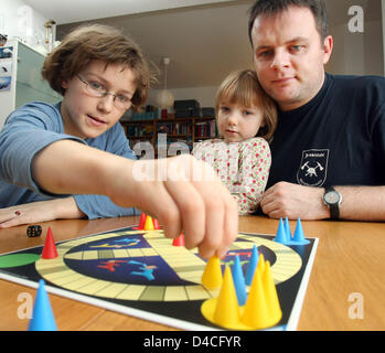 Ruby, Karlotta and Heiko (L-R) play the board game 'Fang den Hut' ('Catch the Hat') in Freiburg, Germany, 20 January 2008. The game was invented in 1927 by Ravensburger AG. Photo: Patrick Seeger Stock Photo