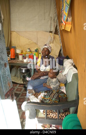 The picture shows 23-year old Naomi with her children in her makeshift dwelling in the Huruma slum in Nairobi, Kenya, 28 November 2007. The single mother of two makes a living as a laundry woman earning 1.50 euro per day. Photo: Sandra Gaetke Stock Photo