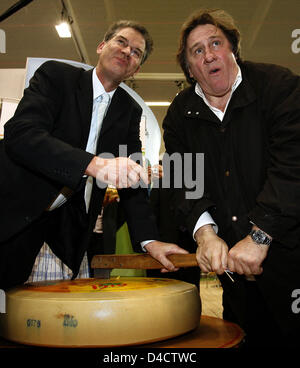 French actor Gerard Depardieu (R) and parliementary state secretary of the Federal Ministry for Consumer Protection, Food and Agriculture, Gerd Mueller, cut a cheese at the BioFach 2008 trade fair in Nuremberg, Germany, 21 February 2008. Depardieu opened the world's leading organic trade fair runnig from 21 to 24 February 2008. Photo: DANIEL KARMANN Stock Photo