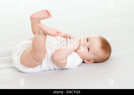 adorable child drinking from bottle. 6 months old girl. Stock Photo