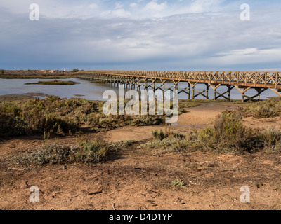 Longest wooden pedestrian bridge in Europe over Creek and Saltmarsh in Ria Formosa Nature Park near Faro Portugal Stock Photo