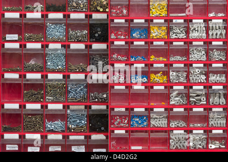 Red box background with many different screws Stock Photo