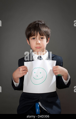 Sad boy with drawing of happy face Stock Photo