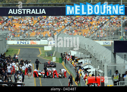 Mechanics push a car back into the pit lane during the second practice session of the Albert Park Circuit in Melbourne, Australia, 14 March 2008. The Australian Formula One Grand Prix will take place on Sunday 16 March. Photo: GERO BRELOER Stock Photo