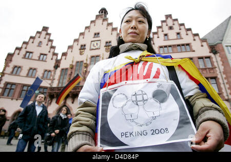 A Tibetan woman holds a placard showing the Olympic rings made of handcuffs and barbed wire during a demonstration for a free Tibet in Frankfurt, Germany, 31 March 2008. Many people took to the streets on the International Action Day for Tibet to protest against the actions of Chinese security forces in Tibet. Photo: FRANK MAY Stock Photo