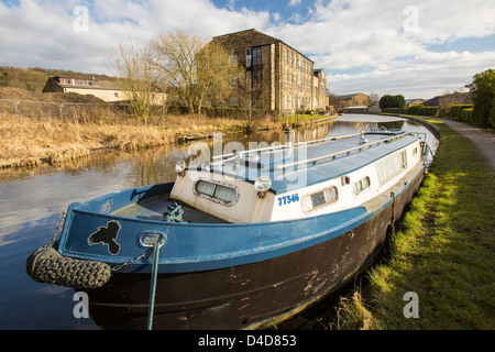 An old cotton mill converted into housing on the Leeds Liverpool Canal at Bingley, West Yorkshire, UK.