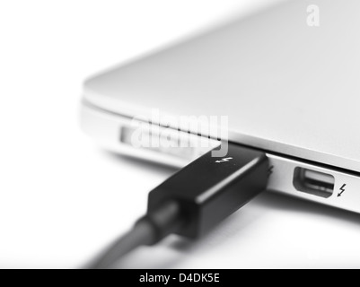 LONDON-JAN.01: photo studio of a thunderbolt cable linked to a laptop on 18th january, 2013 in London,UK. Intel thunderbolt is a new connectivity solution that offer a speed of transfer faster 10 times compared to esata and older connection solution. Stock Photo