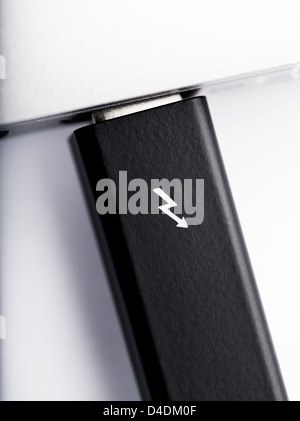 LONDON-JAN.01: photo studio of a thunderbolt cable linked to a laptop on 18th january, 2013 in London,UK. Intel thunderbolt is a new connectivity solution that offer a speed of transfer faster 10 times compared to esata and older connection solution. Stock Photo